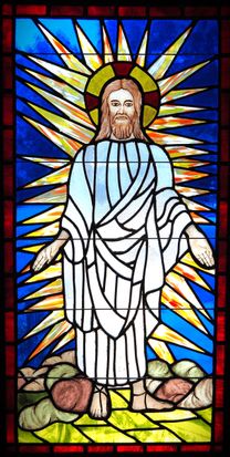 Stained glass window of Christ in radiant white